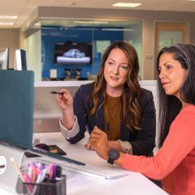 Woman on a laptop reviewing with team